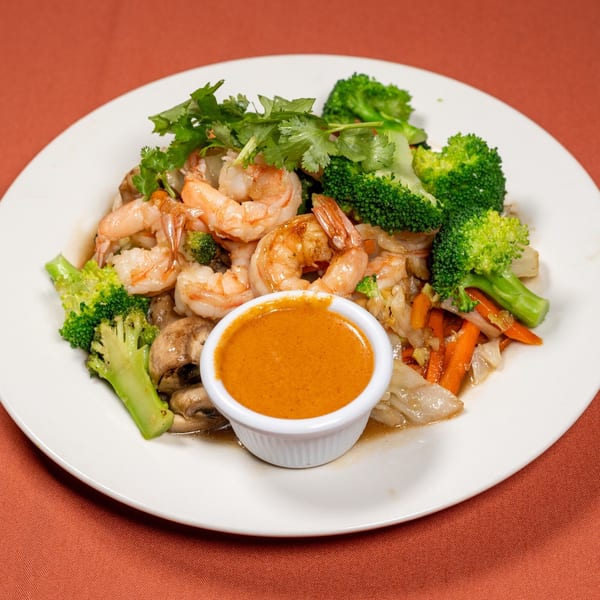 Tasty Thai Kitchen's shrimp stir-fry with broccoli, carrots, mushrooms, and cilantro, served with peanut sauce.